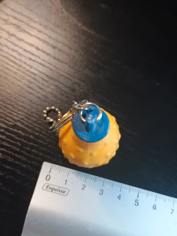 Porte clé en plastique représentant la célèbre bouteille ronde de la boisson à l'orange, Orangina