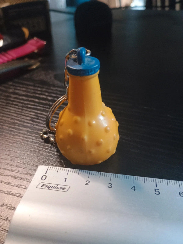 Porte clé en plastique représentant la célèbre bouteille ronde de la boisson à l'orange, Orangina